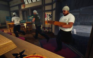 Three cooks in white T-shirts and caps hurry across the dining room of a ramen shop.