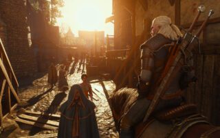 Geralt, seen from behind on horseback, rides down a narrow street of timber houses toward a low, bright sun.